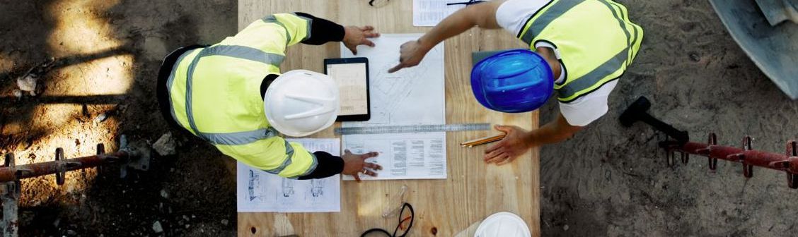 Two men discussing plans at a job site